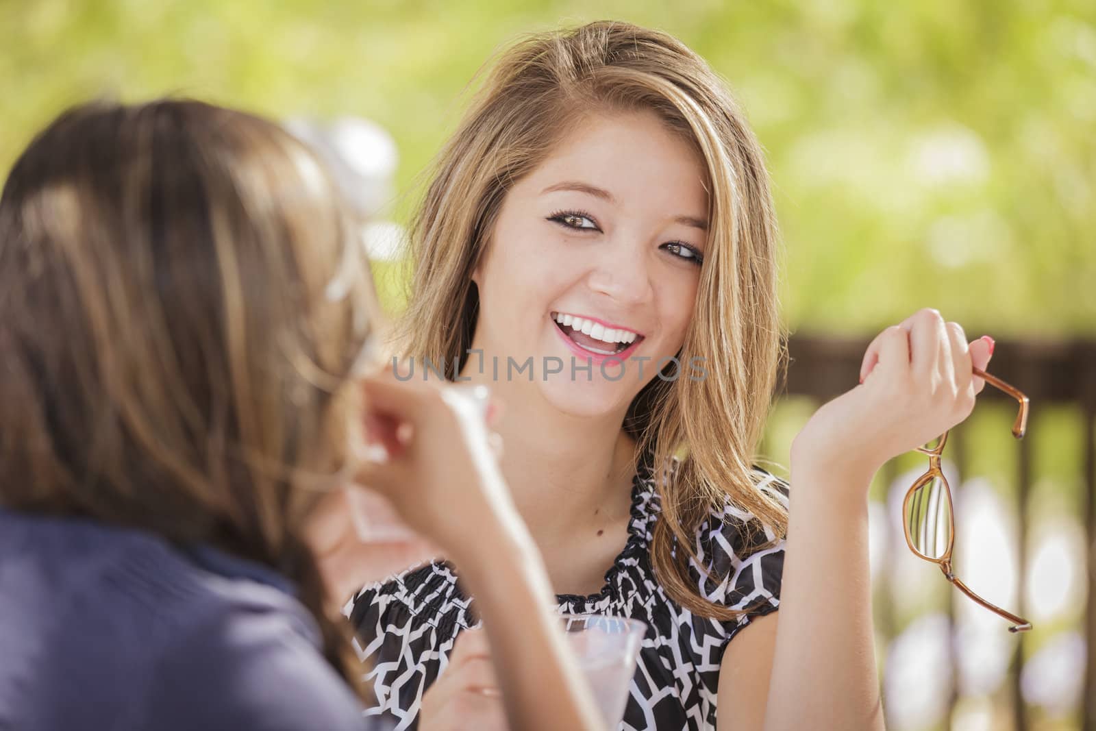 Attractive Mixed Race Girlfriends Talking Over Drinks Outside by Feverpitched