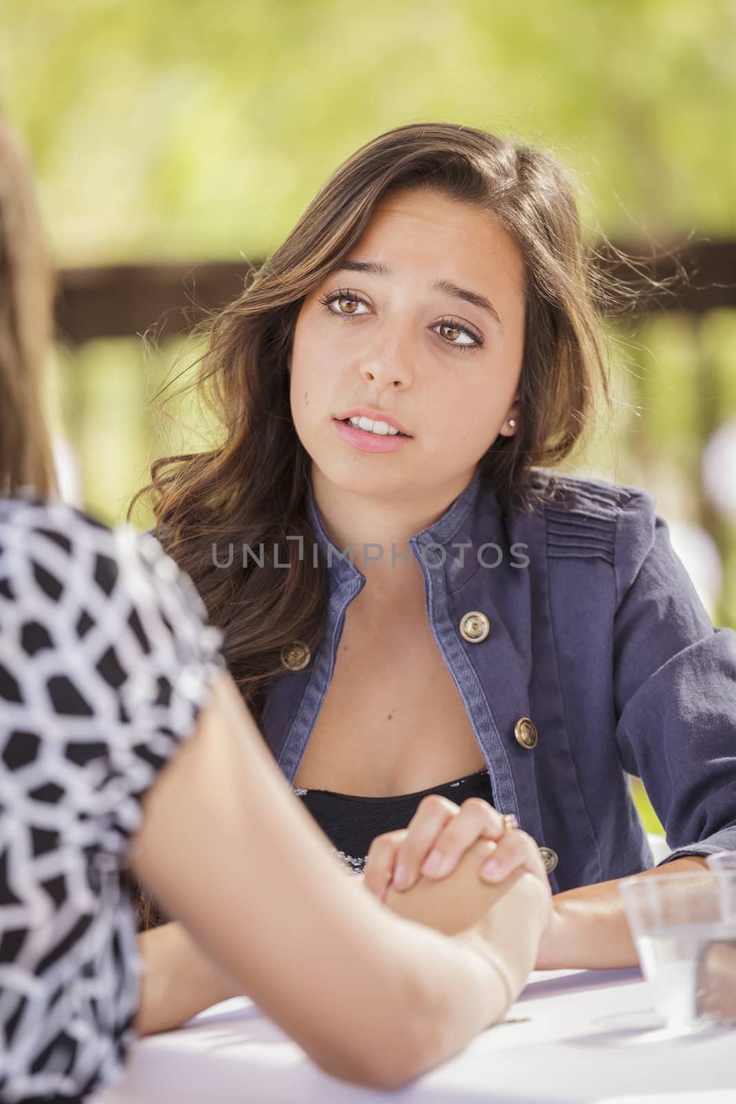 Attractive Girl Comforting A Friend Sitting Outdoors.