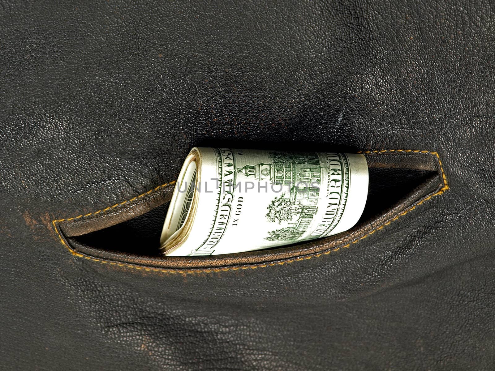 Pack of dollars in a pocket of a leather jacket.