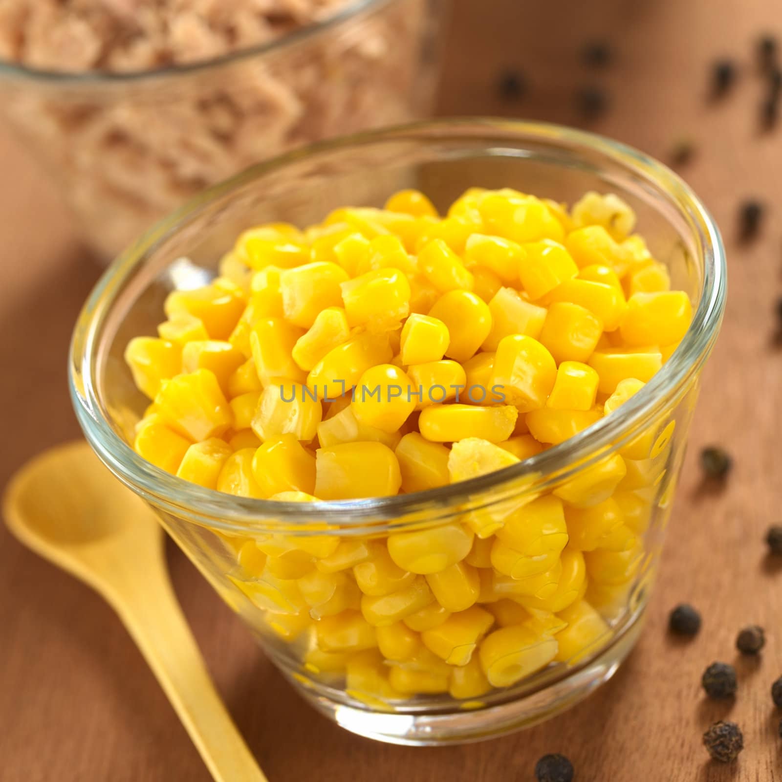 Sweet corn grains and tuna in glass bowls with black pepper corns on the side (Selective Focus, Focus one third into the corn)