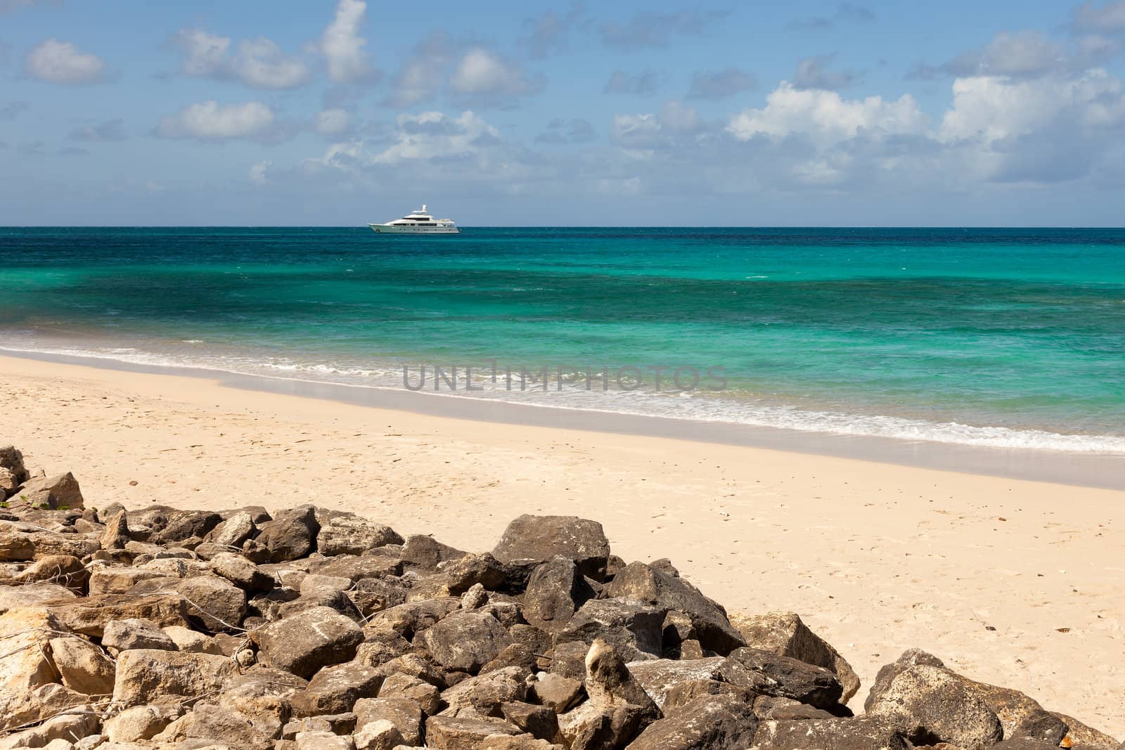 Tropical Caribbean Beach Seascape with Motor Yacht and Blue Sky on Beautiful Sunny Day