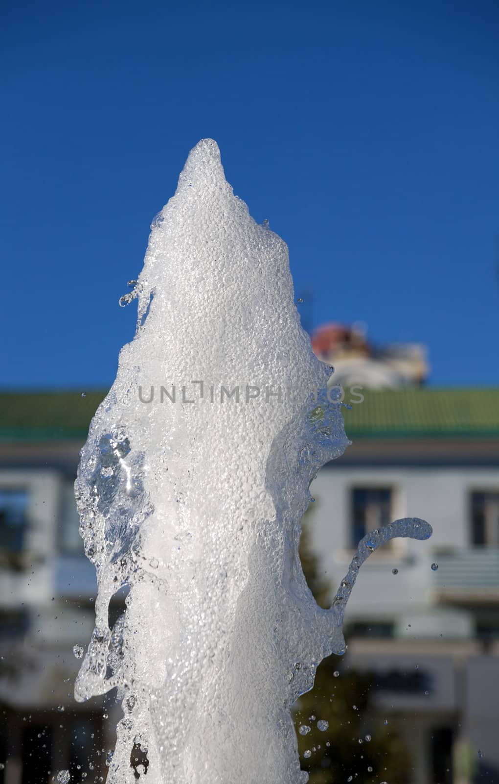 Fountain of pure brilliant water against a blue clear sky
