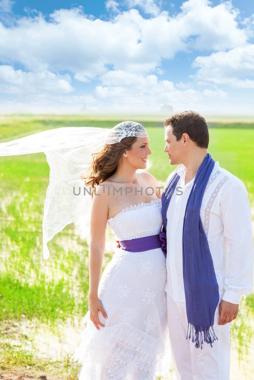 Couple in wedding day outdoor with wind on veil