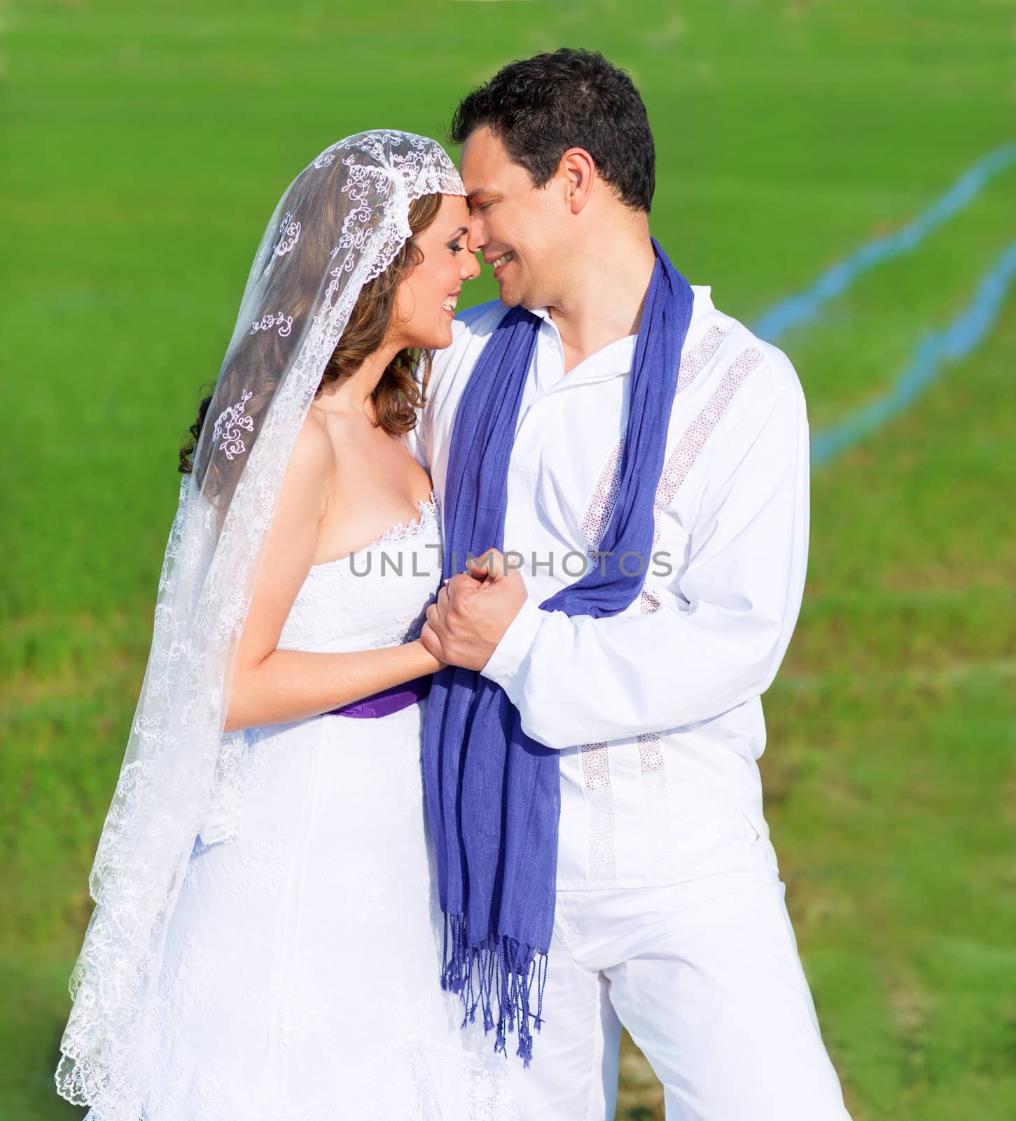 Couple in wedding day hug in outdoor green meadow