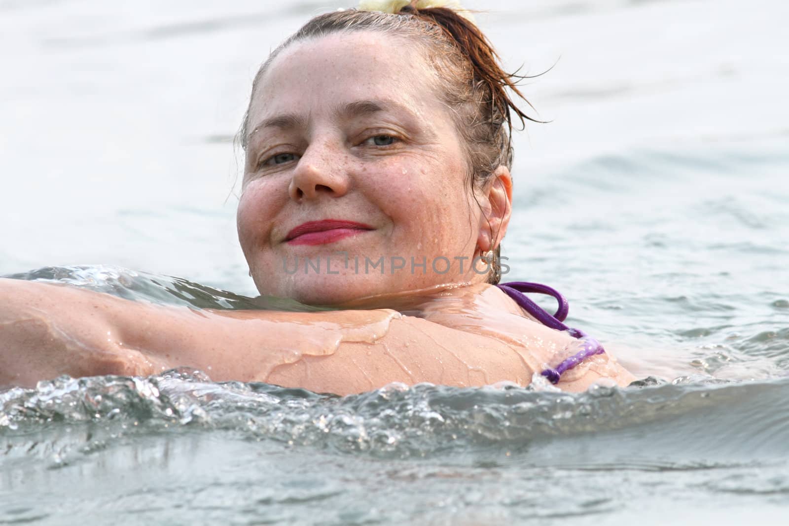 Smiling woman swimming in the water