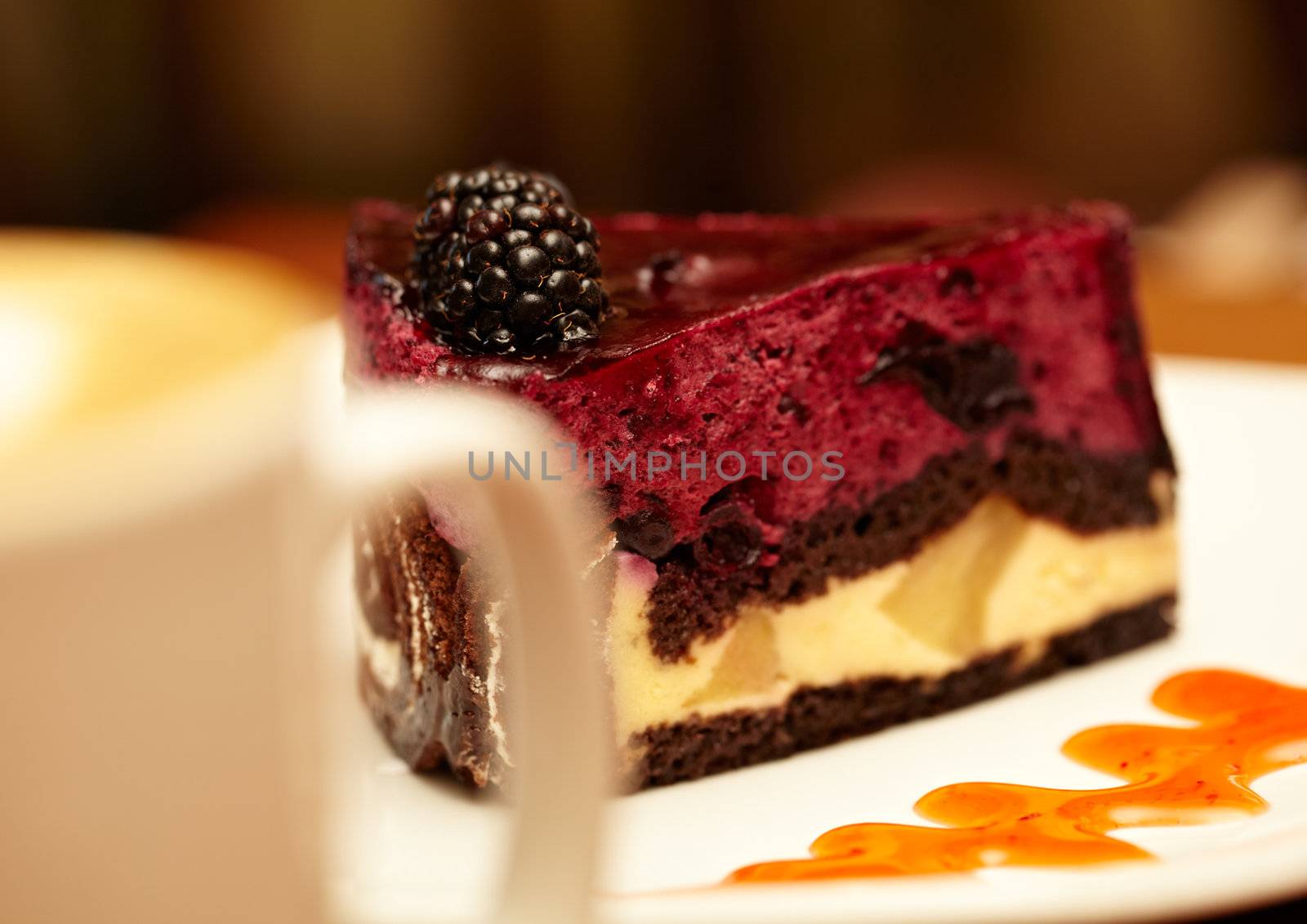 Cheesecake with blackberry on a plate and a cup of coffee, shallow dof.