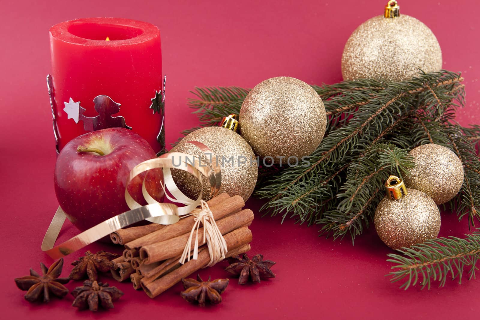 christmas decoration aromatic red apple, cinnamon, anise and tree on red background