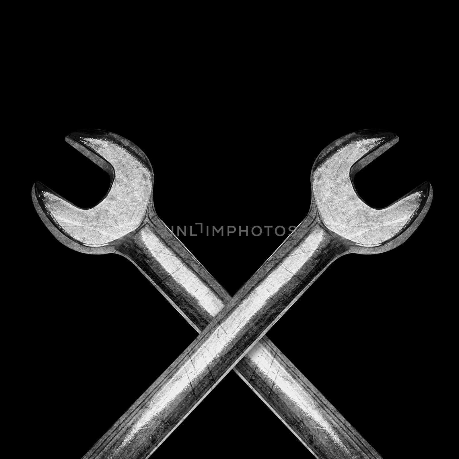 Two spanners or wrenchs on black background.