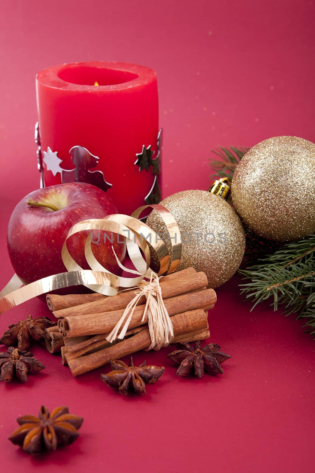 christmas decoration aromatic red apple, cinnamon, anise and tree on red background