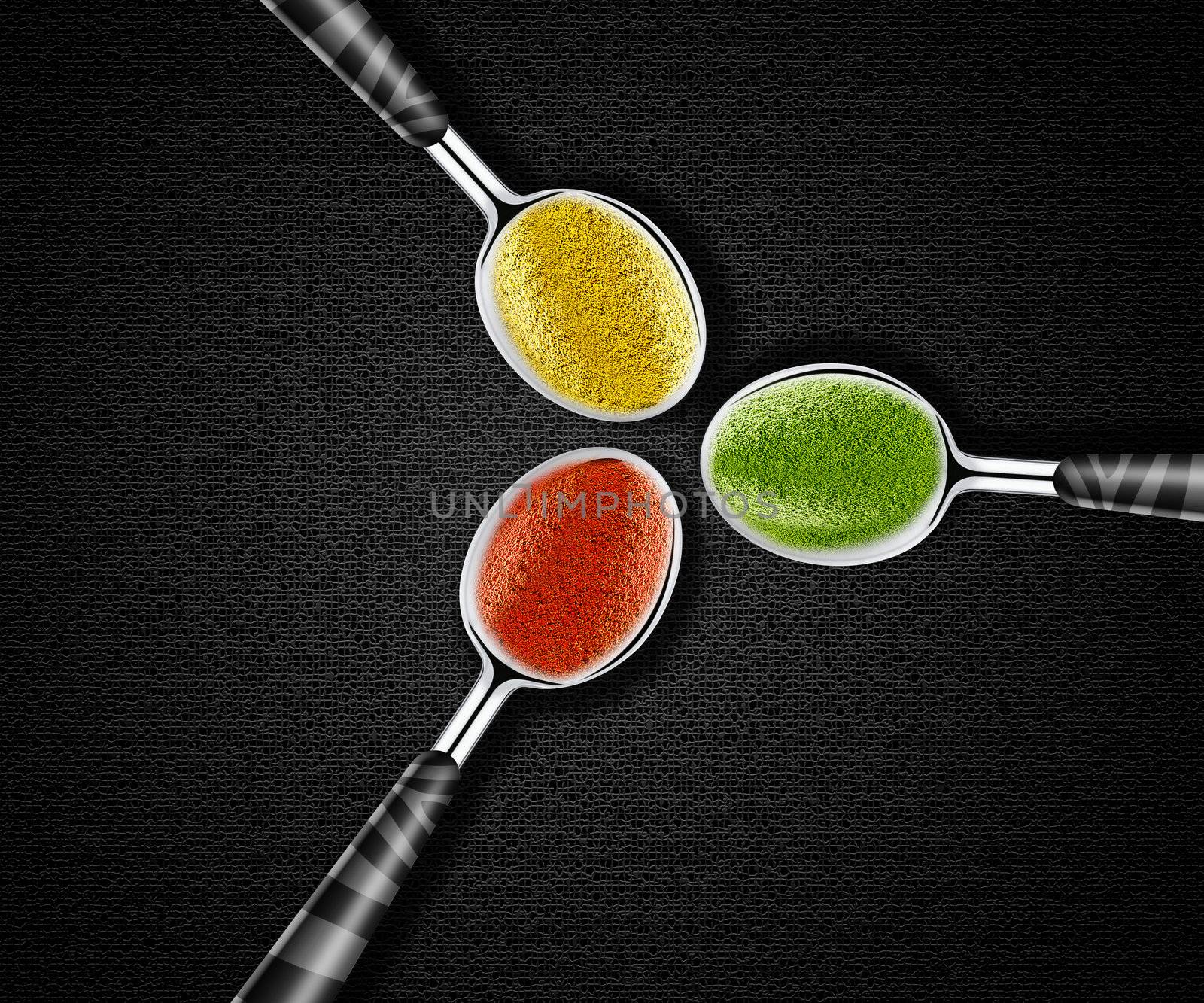 Collection of green, yellow and red spices on spoons onblack background