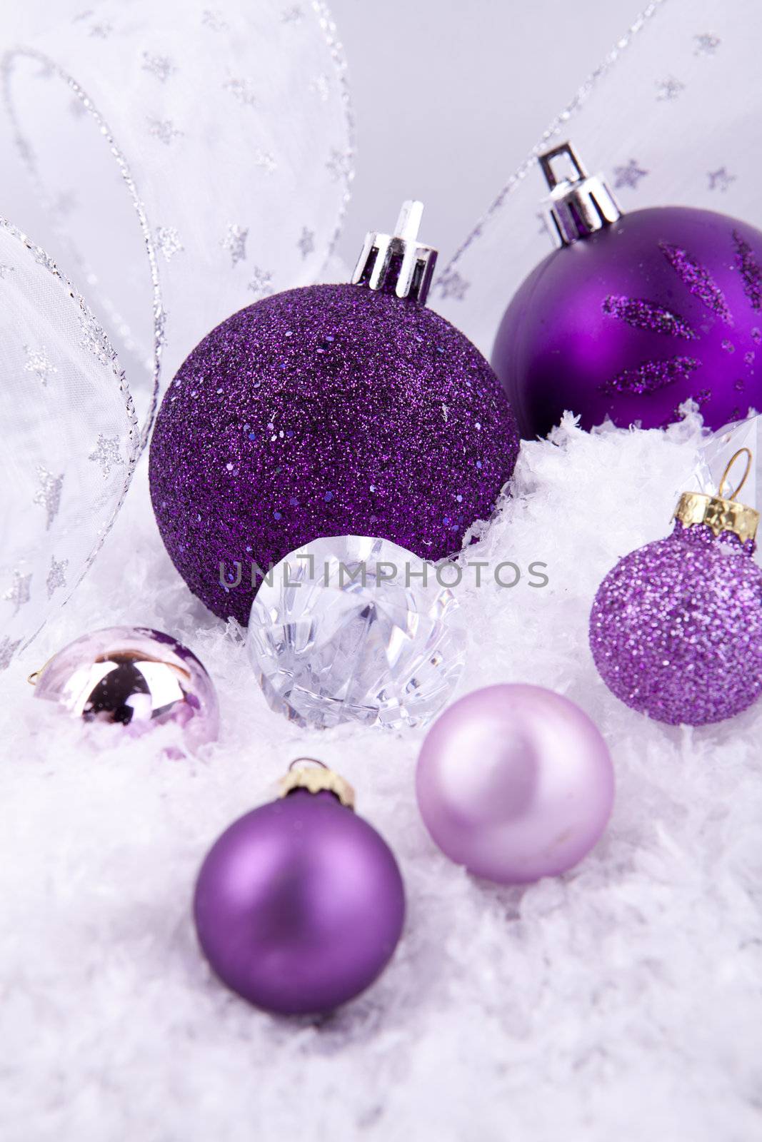 beautiful christmas decoration in purple and silver on white snow sparkle