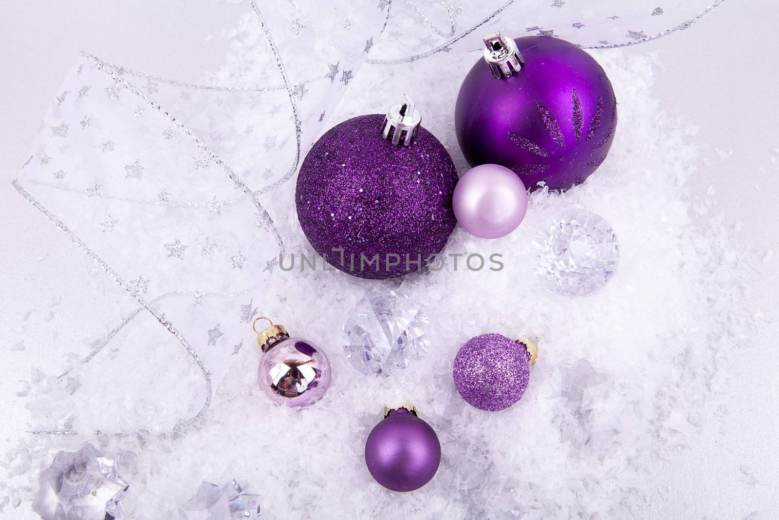 beautiful christmas decoration in purple and silver on white snow sparkle