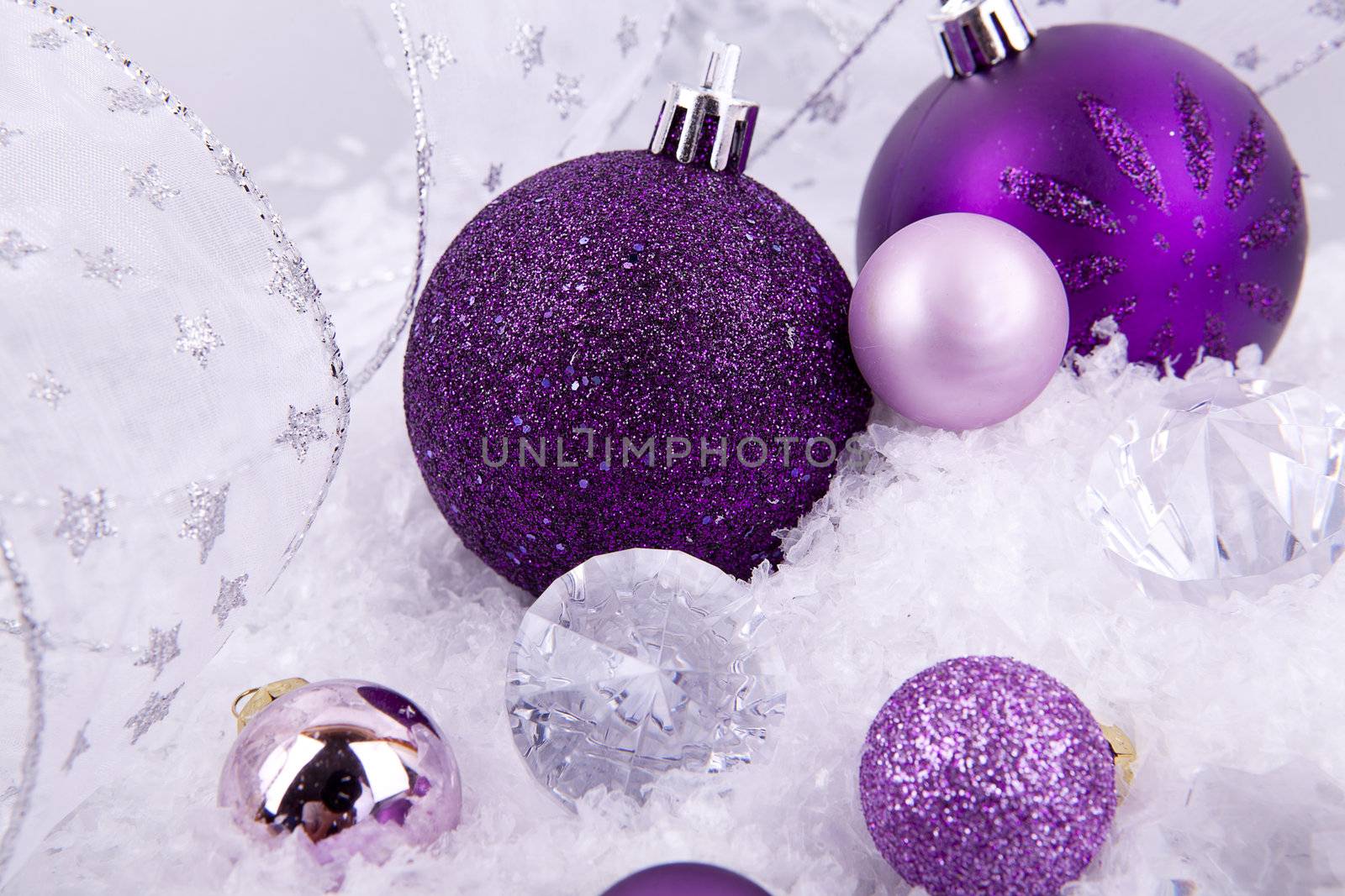 beautiful christmas decoration in purple and silver on white snow sparkle