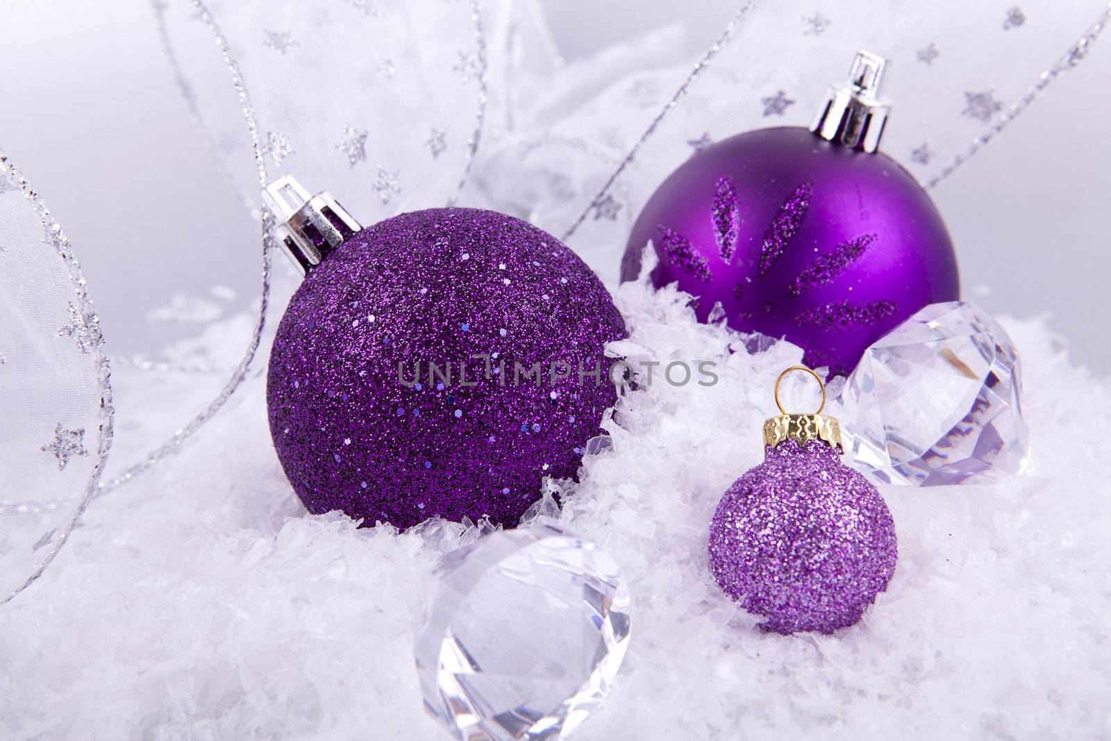 beautiful christmas decoration in purple and silver on white snow sparkle