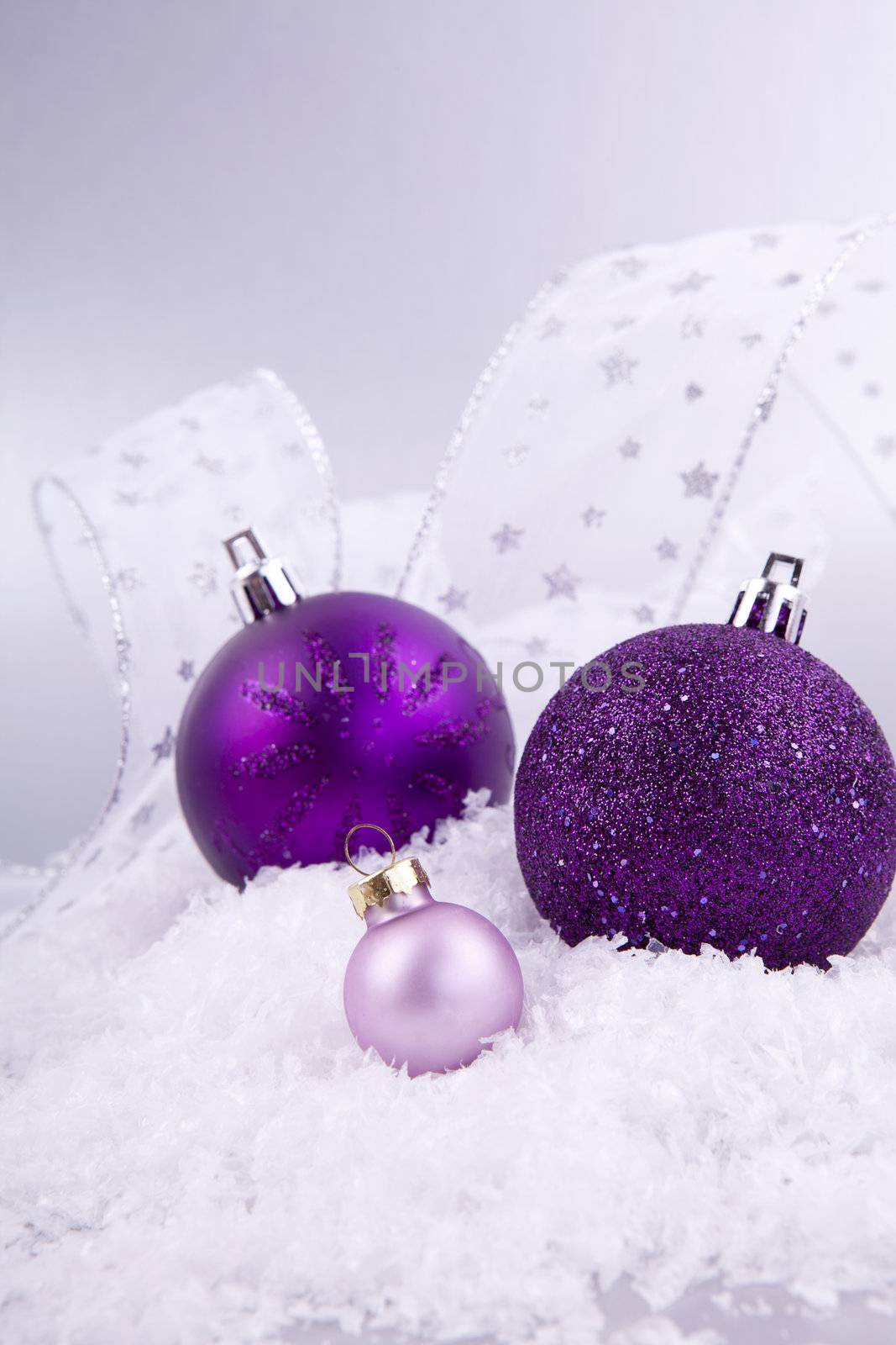 beautiful christmas decoration in purple and silver on white snow sparkle