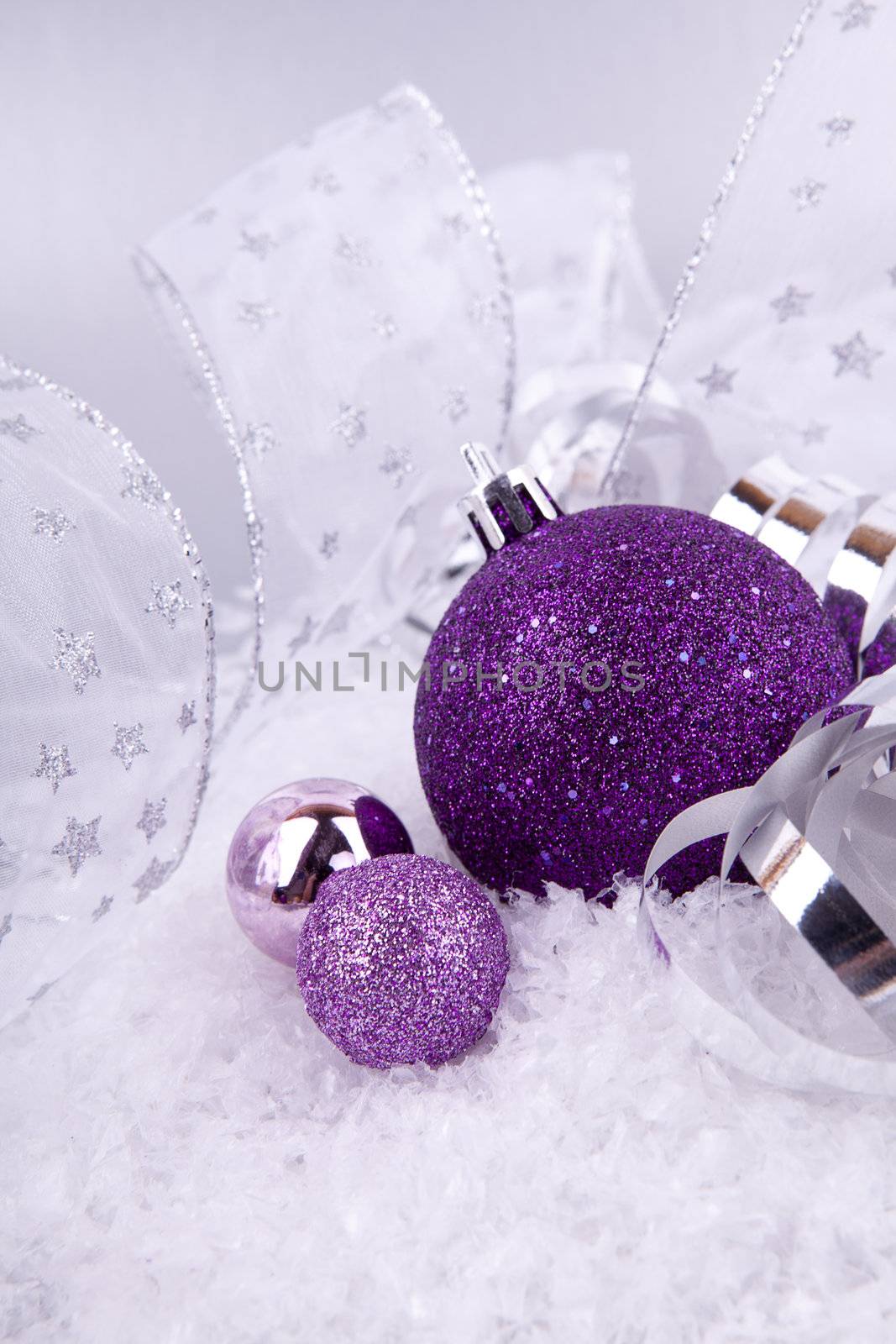 beautiful christmas decoration in purple and silver on white snow sparkle