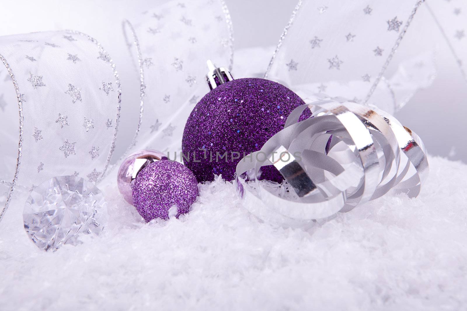 beautiful christmas decoration in purple and silver on white snow sparkle