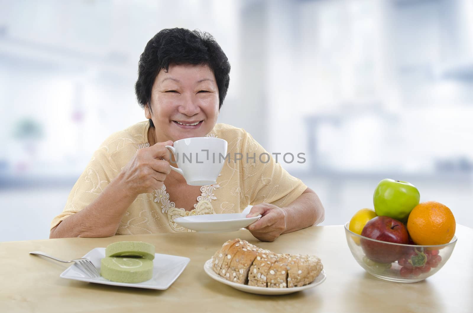 Asian senior woman having breakfast at home