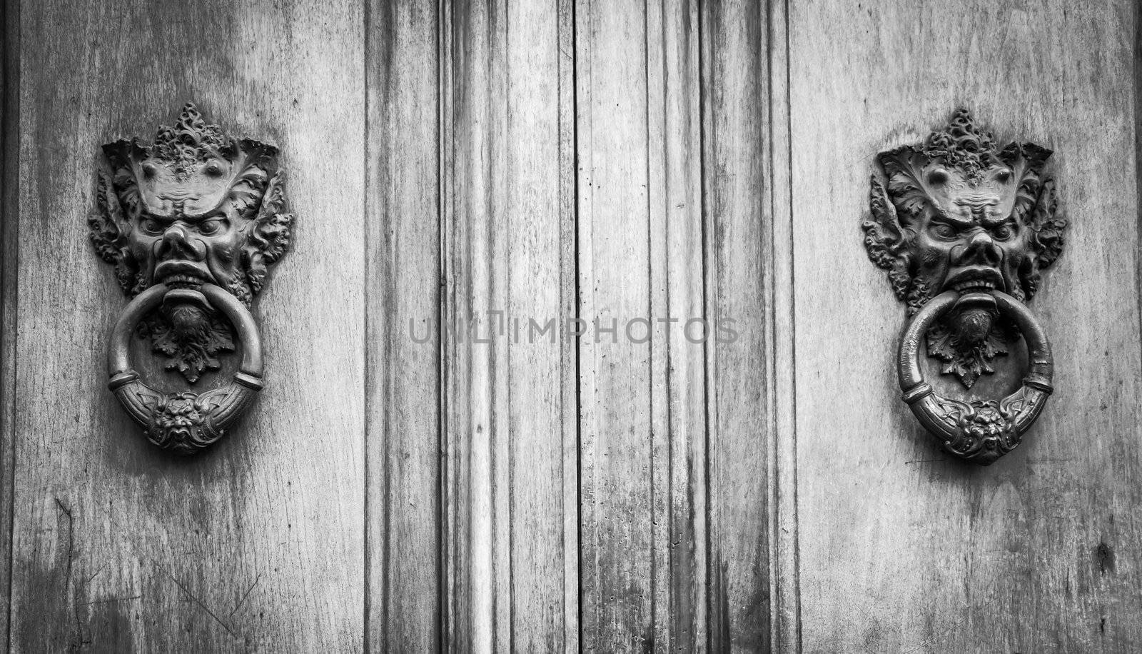 Florence, Tuscany, Italy. Old door with demons on the knob