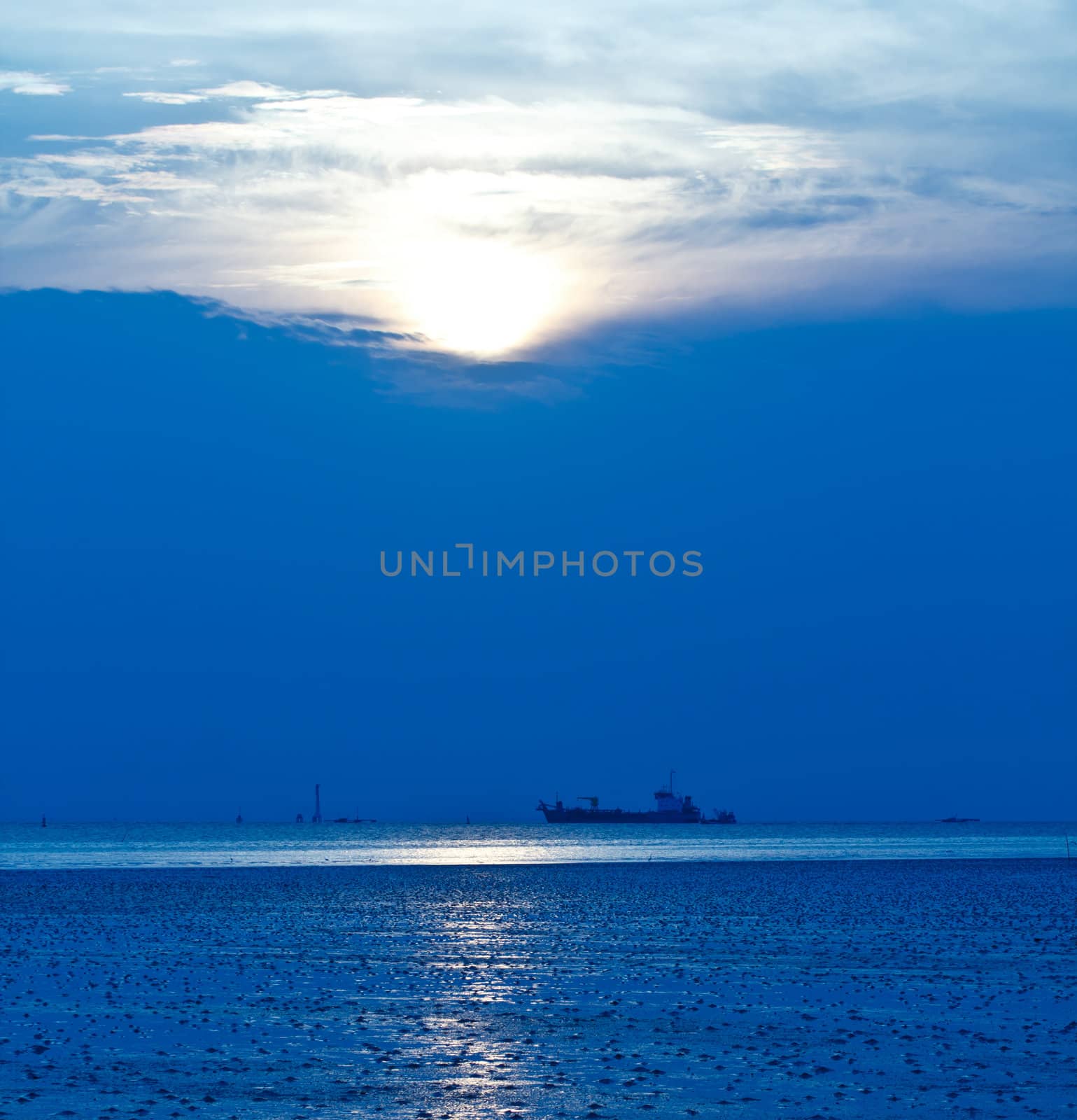 Blue sea with ocean liner at sunset