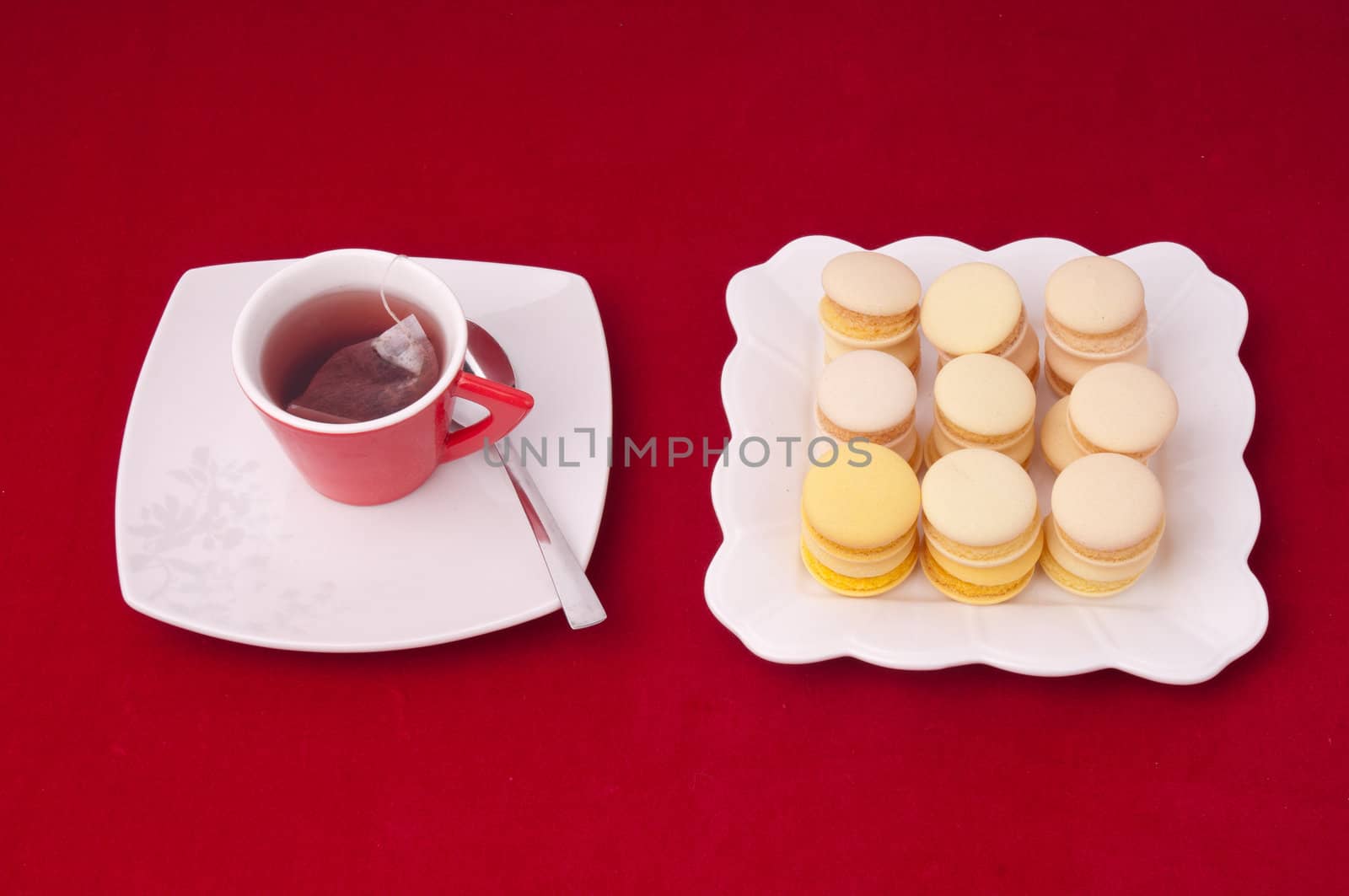 Cup of tea and stacked and aligned macaroons on a velvet tableclothe
