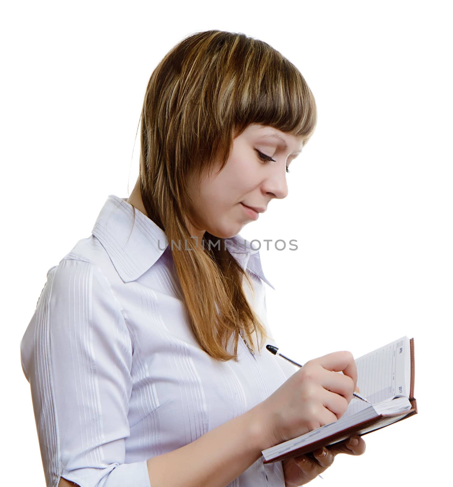 young girl in a white blouse writes in a notebook