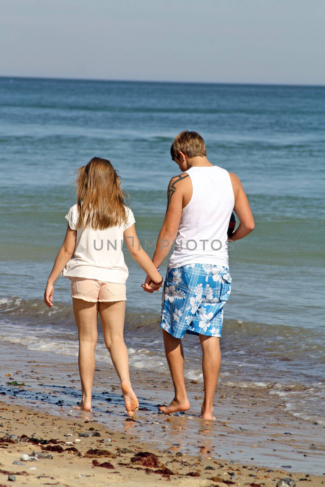 teenagers walking along the beach