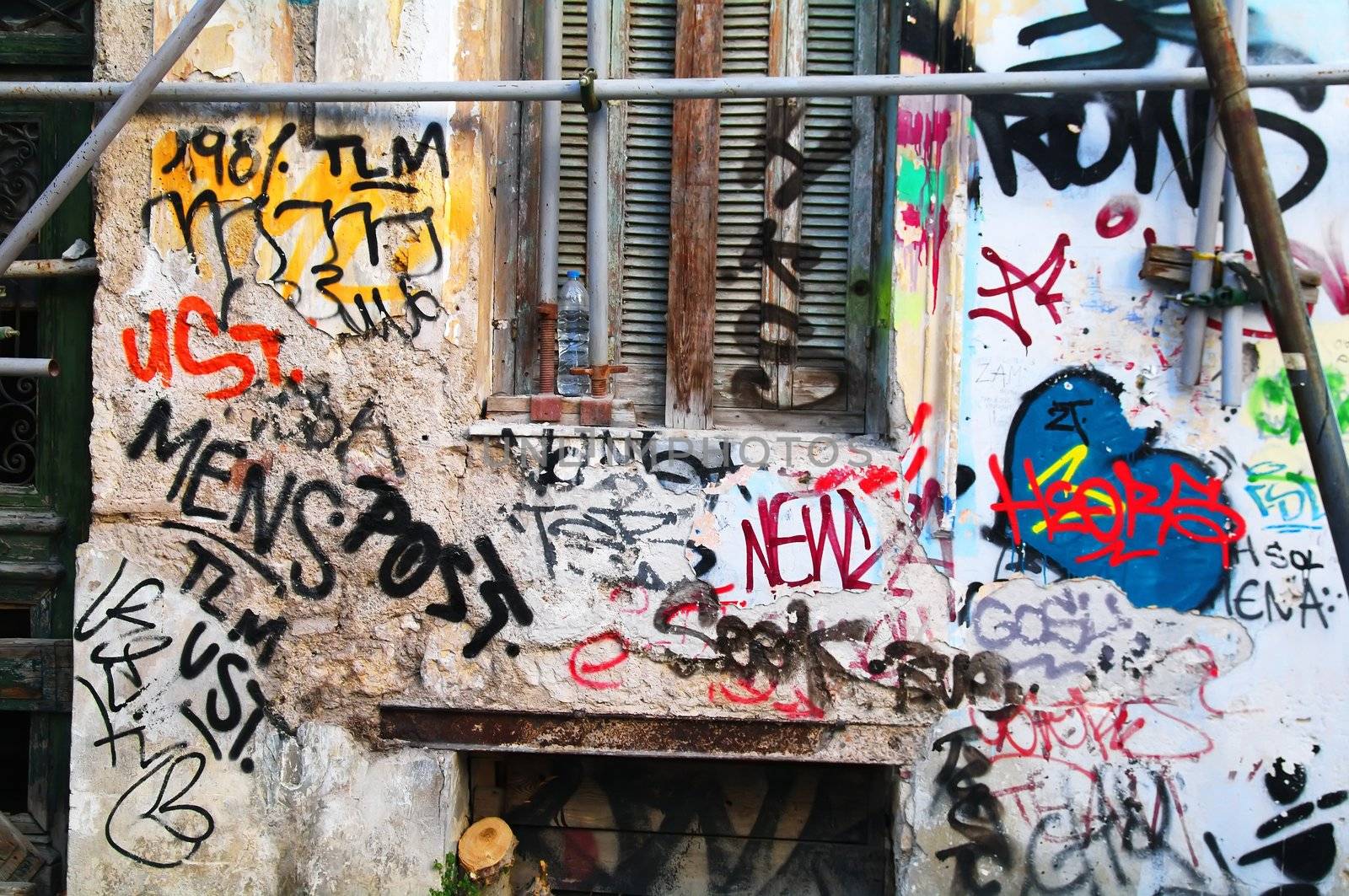 Lot of grafitti on a house wall and window