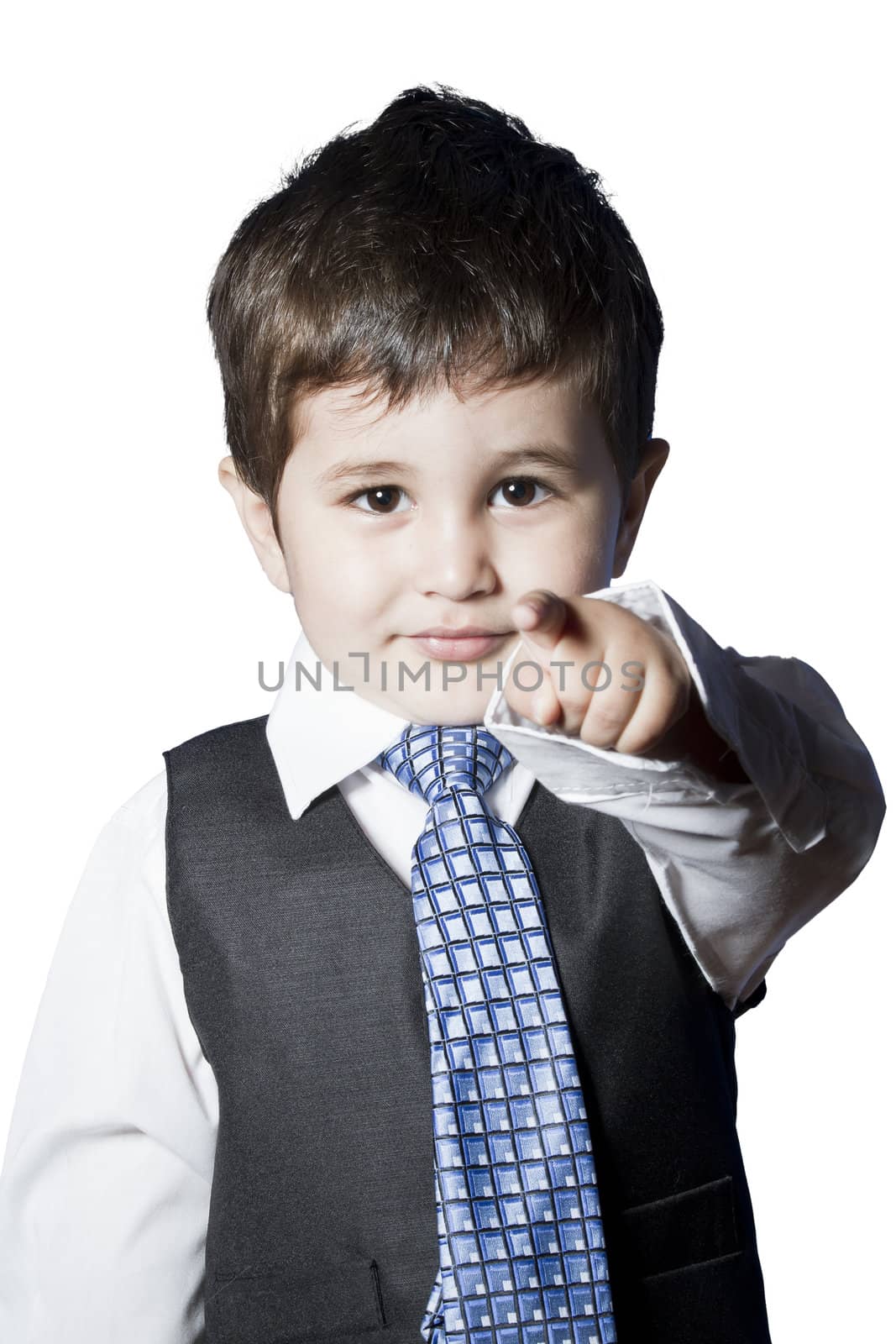 A small boy in the studio, dressed up in a suit and pretending to be a businessman.