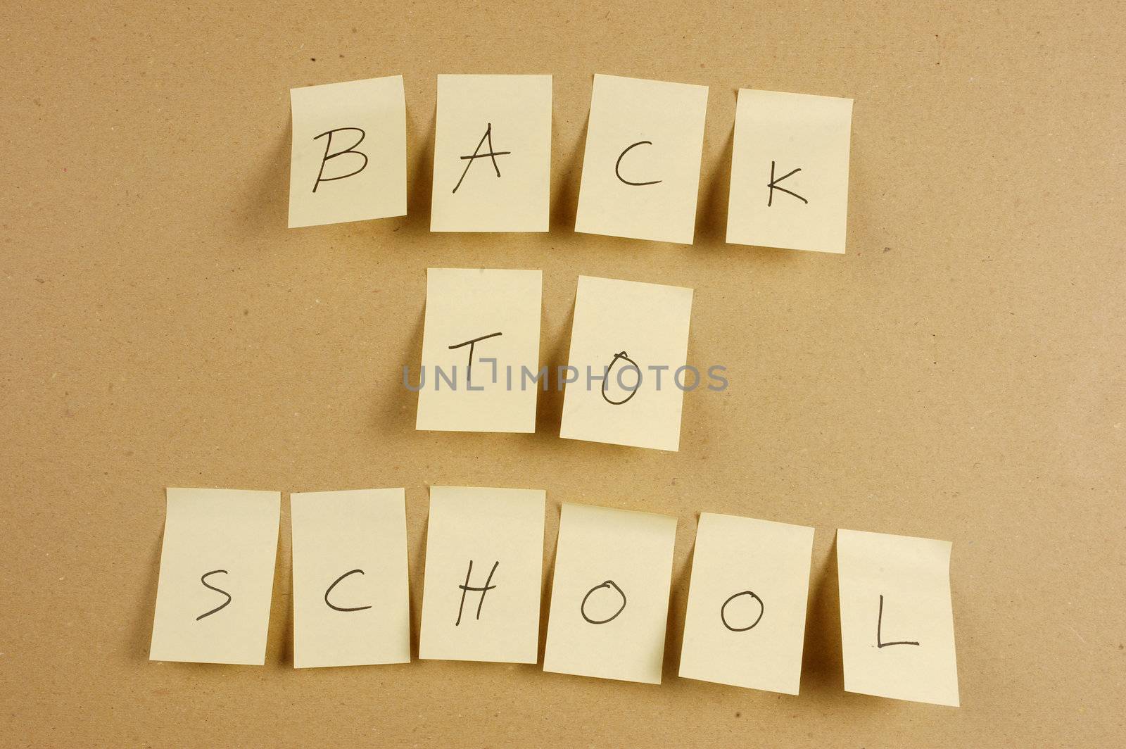 writing back to school is spelled in a sheet of paper affixed to the wall brown carton