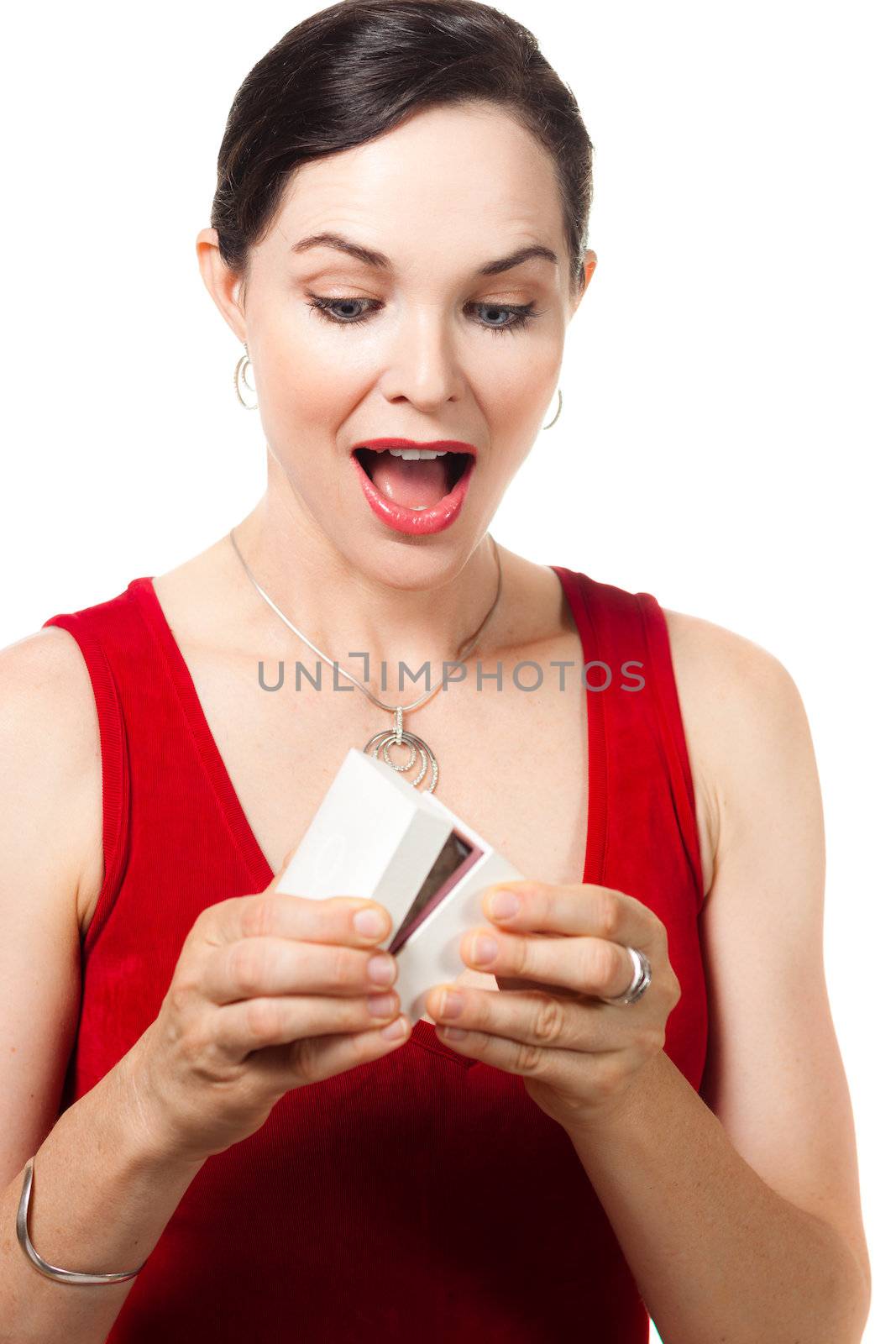 Surprised smiling beautiful woman holding an open jewelery gift box and looking at the present.