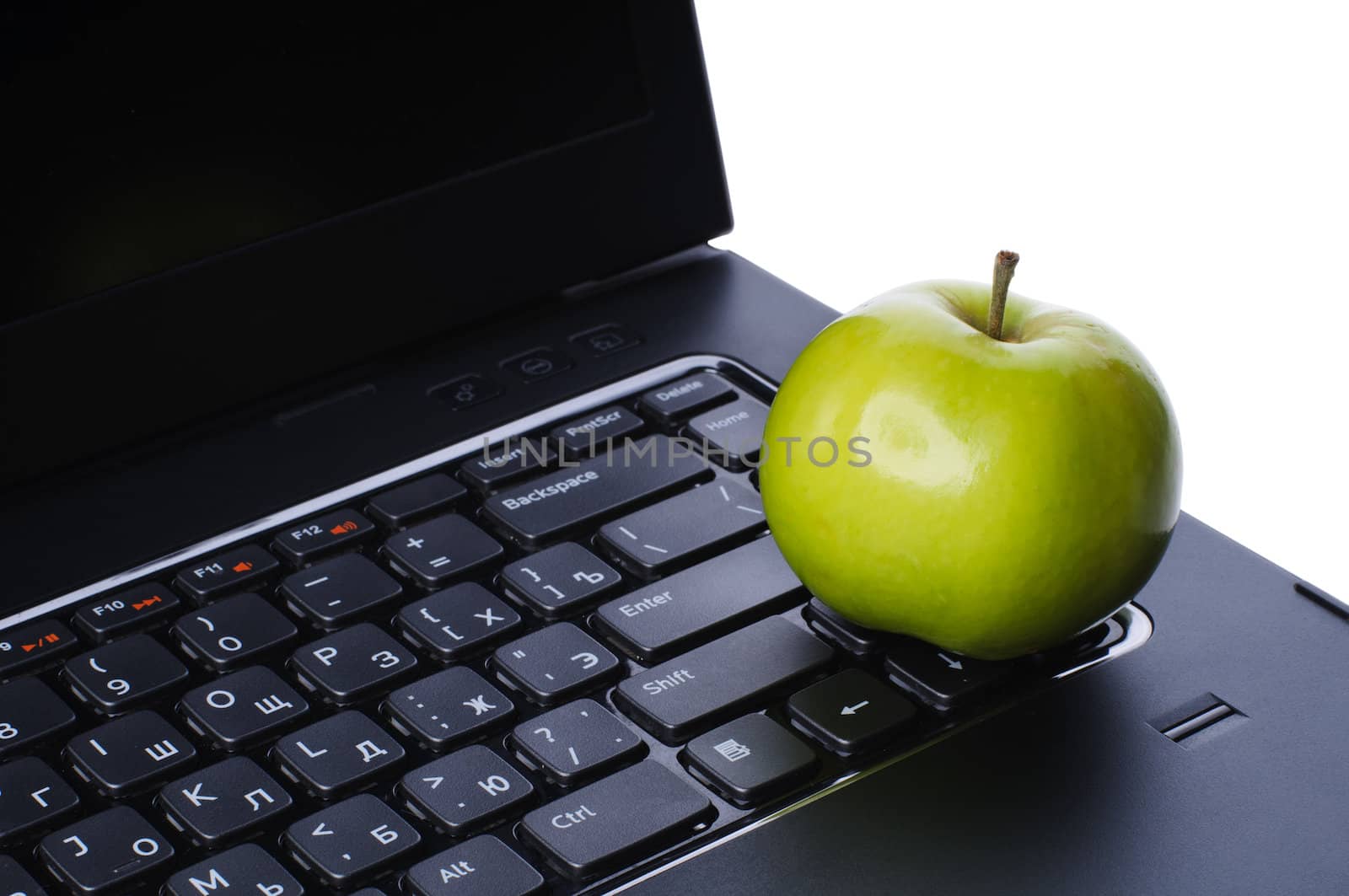 Green apple on laptop keyboard isolated on white background