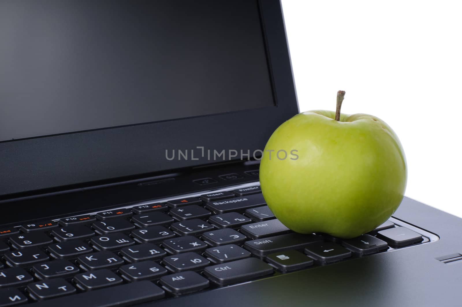 Green apple on laptop keyboard isolated on white background