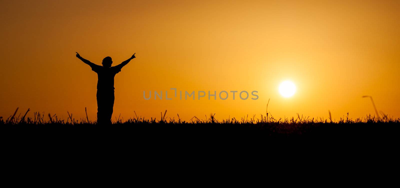 A person is celebrating life at a beautiful sunset or sunrise