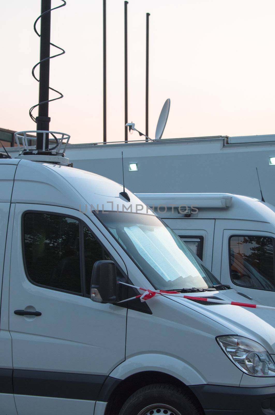 White broadcast trucks recording and broadcasting a live event