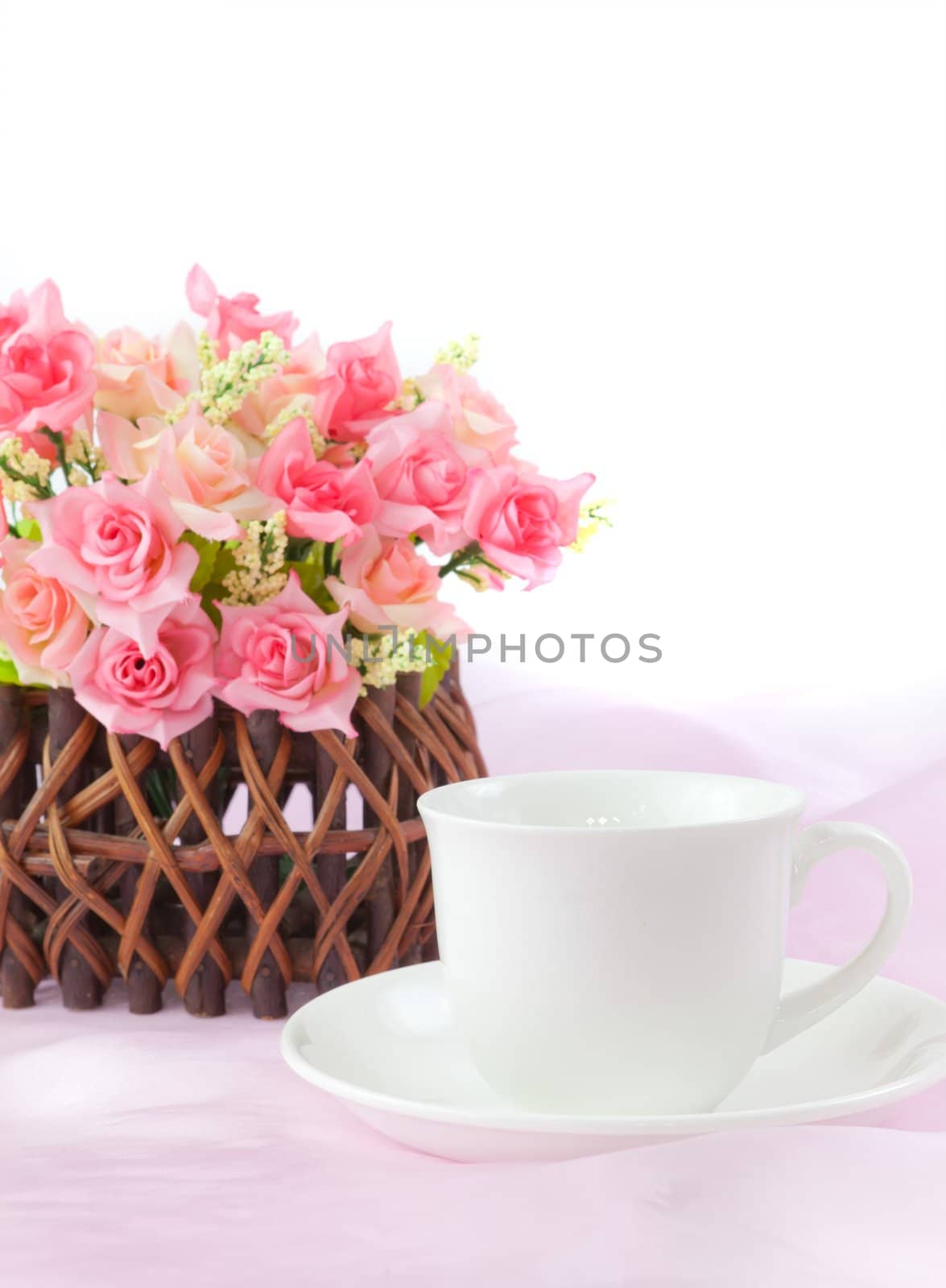 pink roses in wood basket on fabric pink background