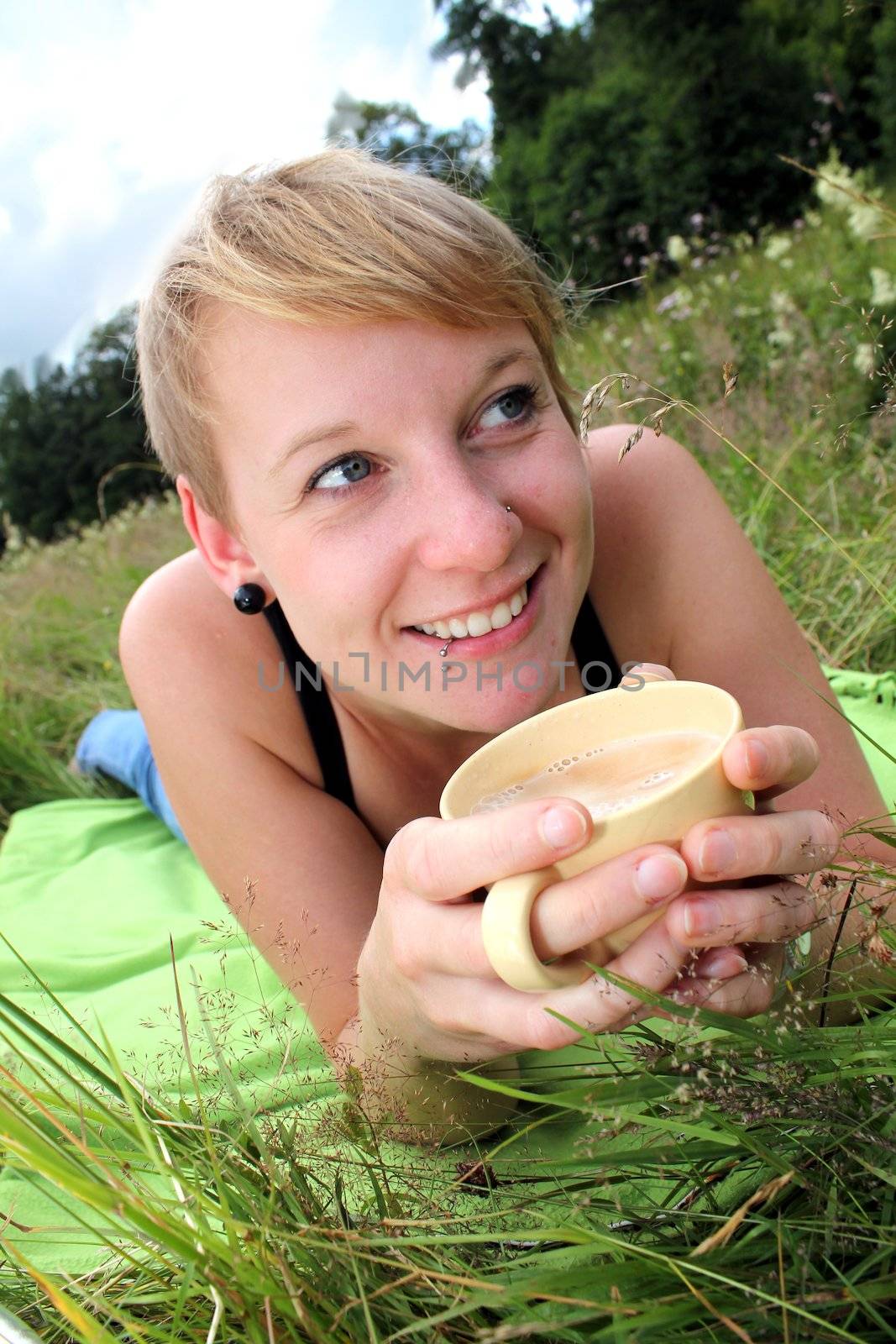 girls is drinking from a cup on a meadow