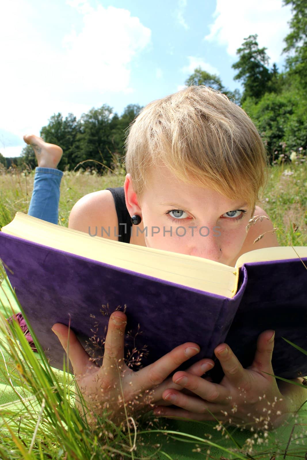 girl is reading a book on a summer meadow by Teka77