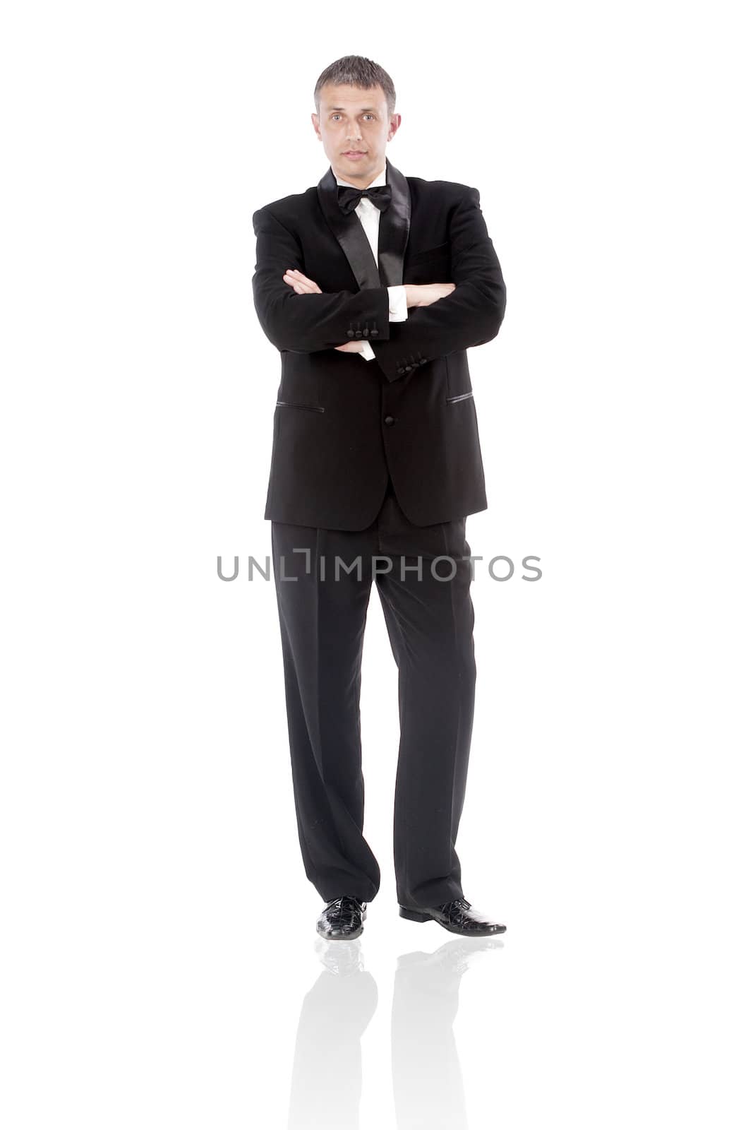 The elegant man in a classical tuxedo on a white background