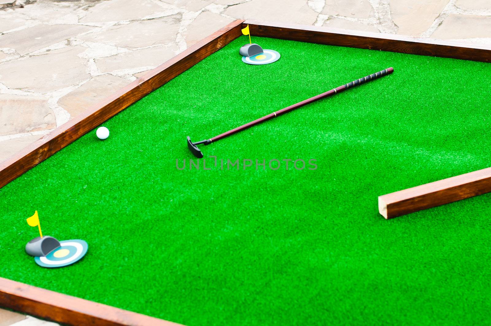 Mini golf field with ball and golf club