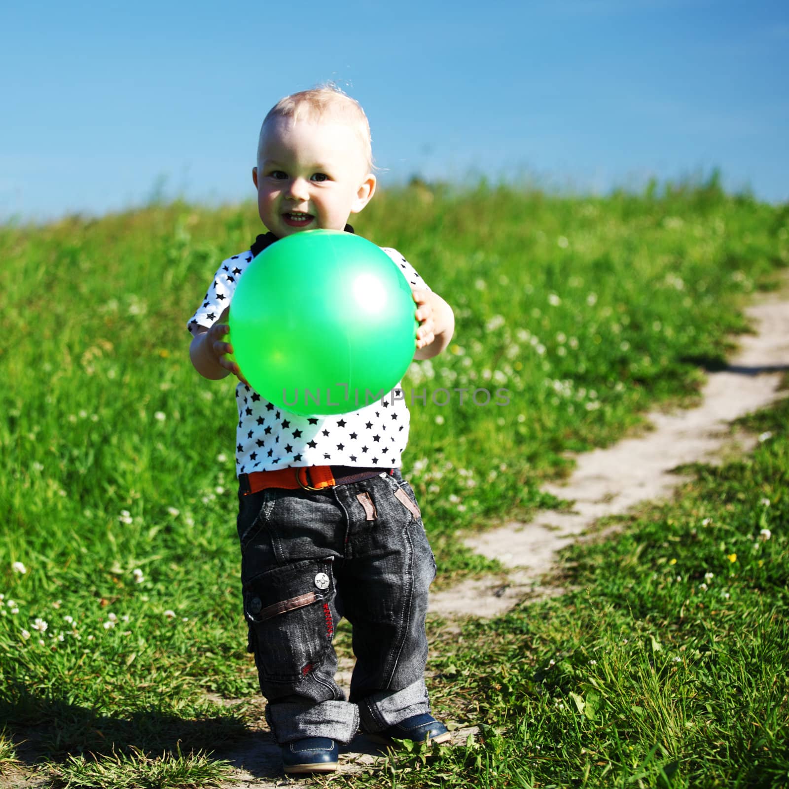  little boy play in green grass with green ball