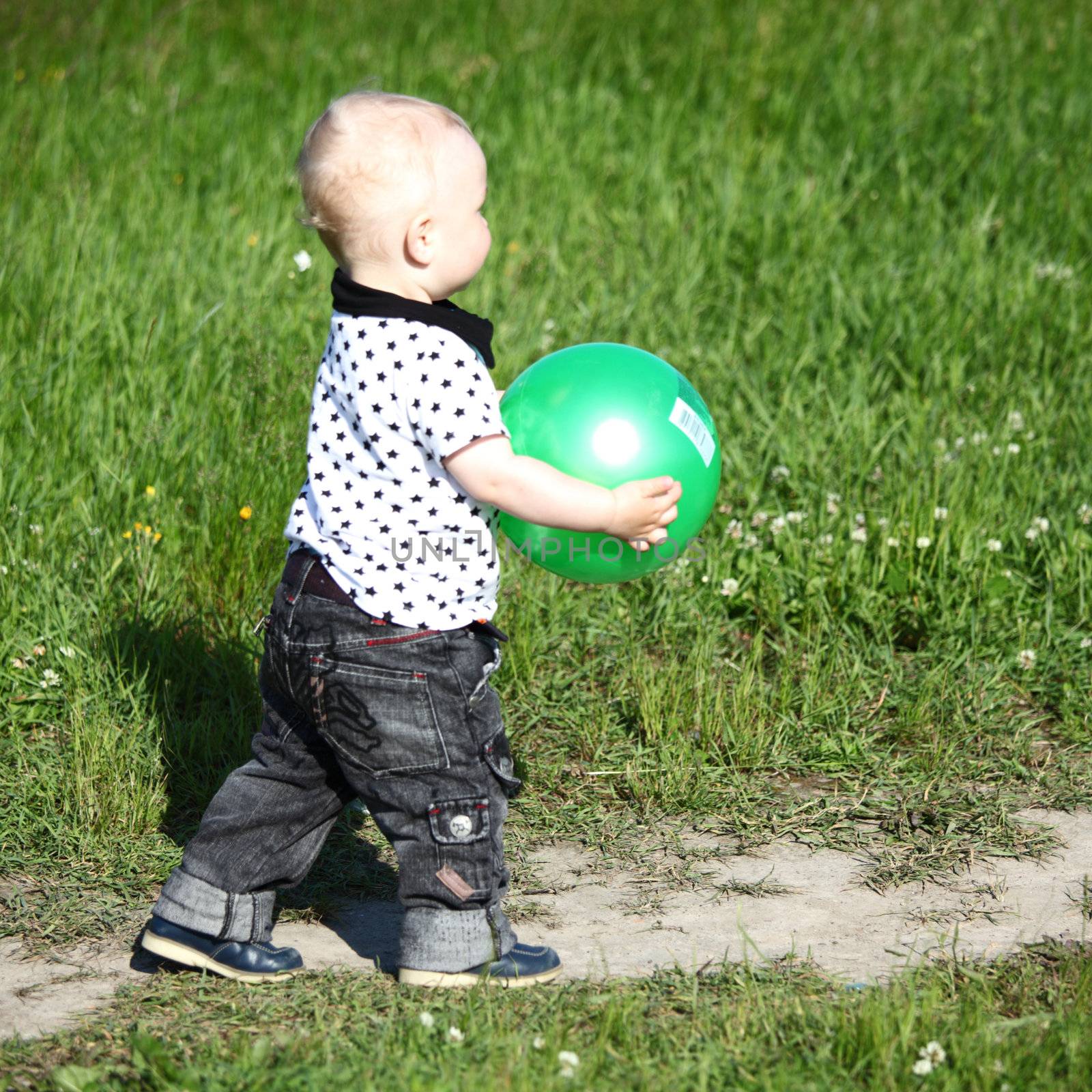  little boy play in green grass with green ball