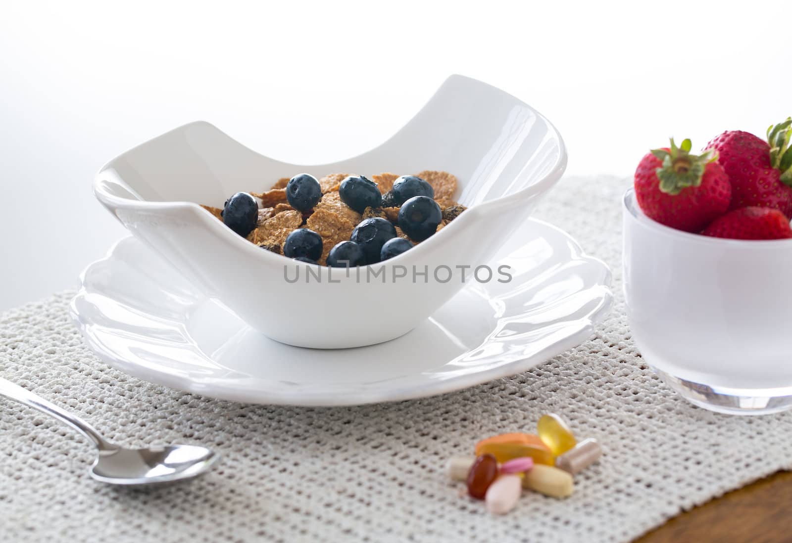 Breakfast of blueberries, bran flakes strawberries in modern pottery bowl