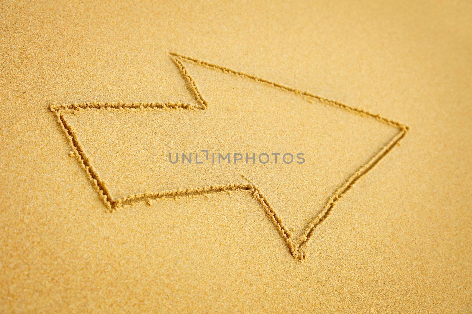 The arrow drawn on beach sand