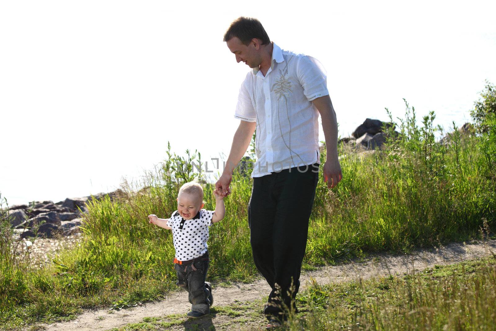 father and son walking on grass