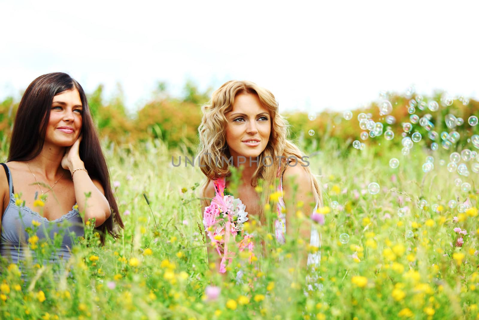 girlfriends on green grass field in soap bubbles