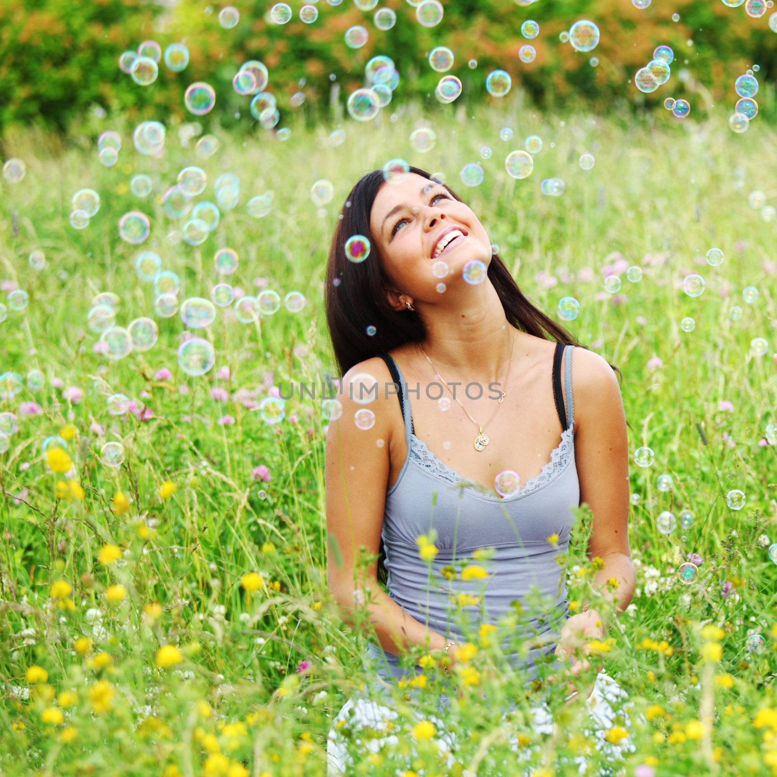 girlfriends on green grass field in soap bubbles