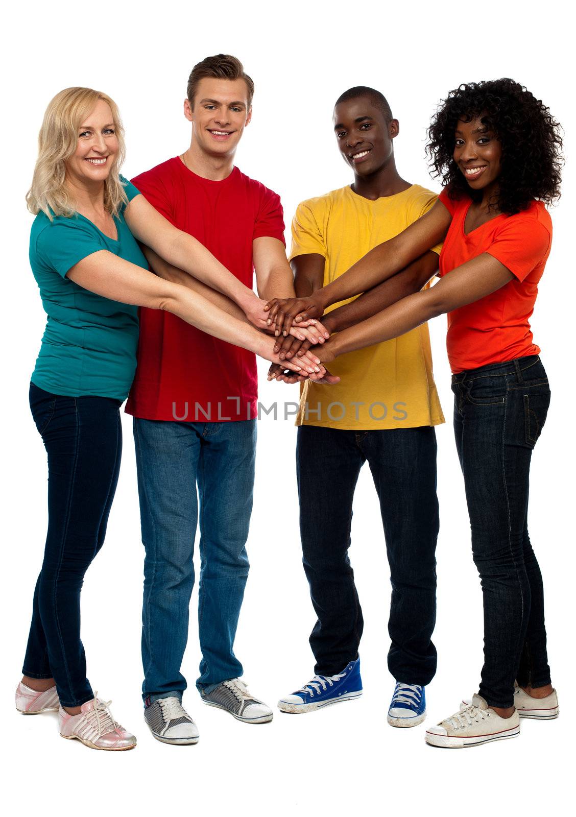 Group of young multicultural friends posing with hands on hands looking at you