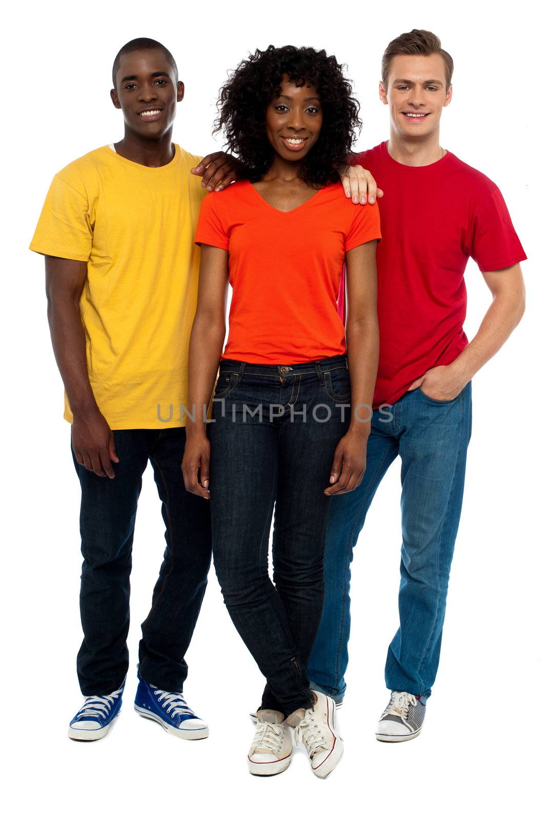 Trio of casual young friends posing in style with guys resting hands on girls shoulder