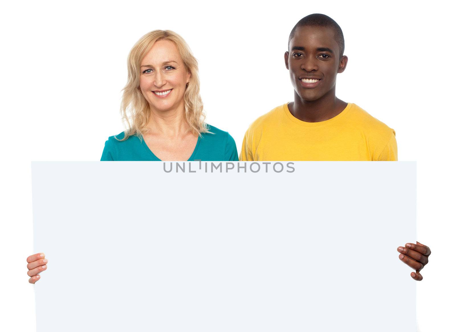 Attractive couple holding white blank ad board looking at you